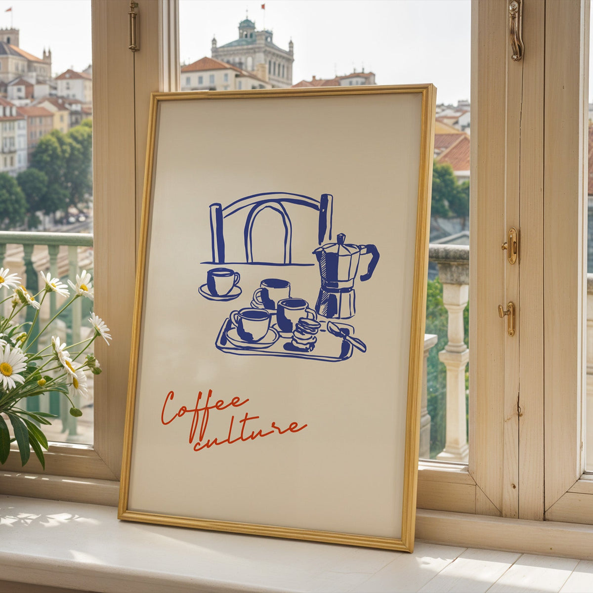 Moka pot print in a gold frame on a window sill overlooking a hillside town