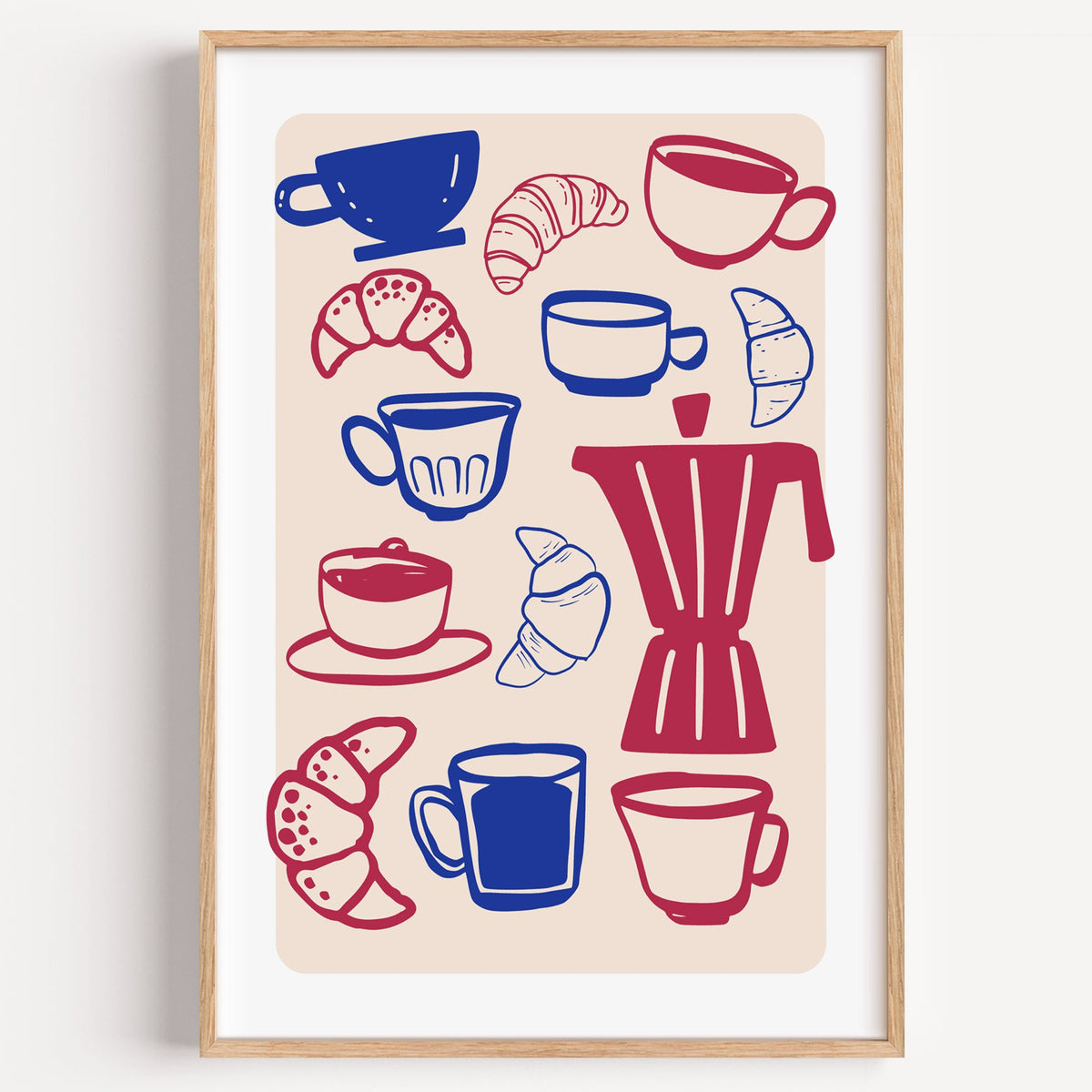 Moka pot, cups and croissants pattern in a light oak frame on a plain white wall