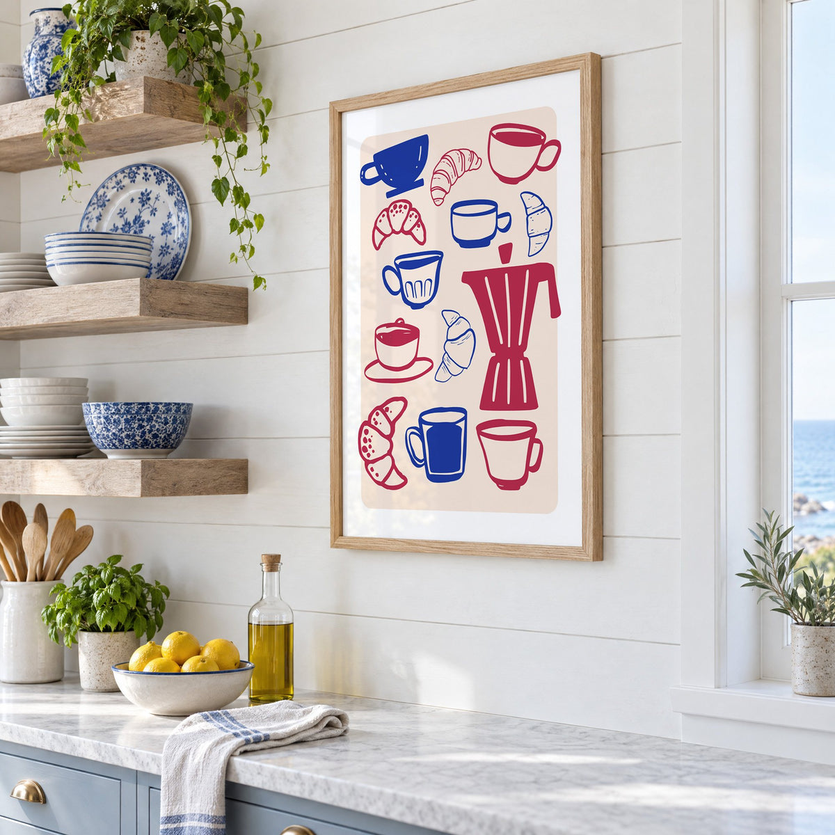 Moka pot, cups and croissants pattern in an oak frame in a white coastal kitchen beside blue and white plates