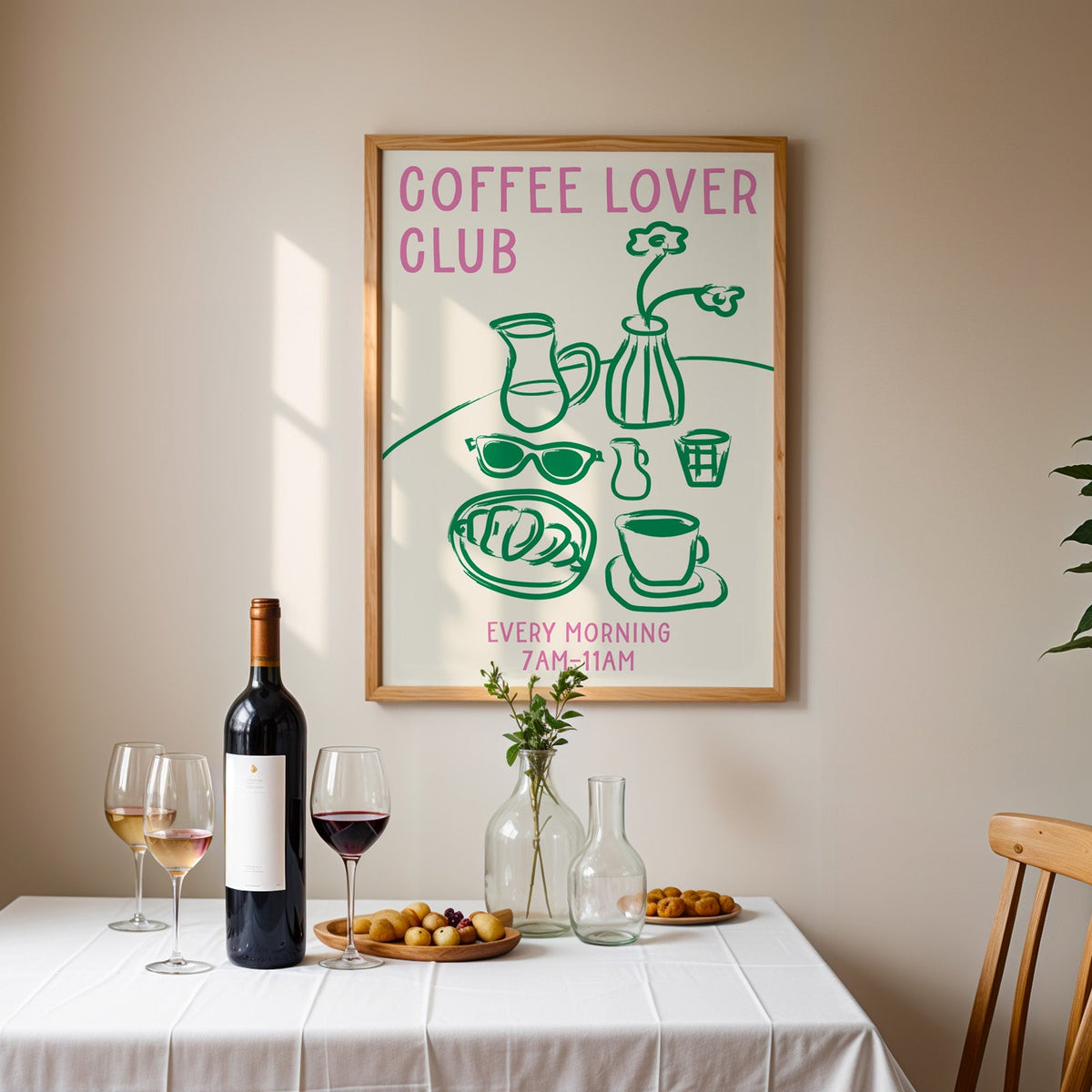 Coffee lover club morning print in an oak frame above a table laid with red wine and glasses