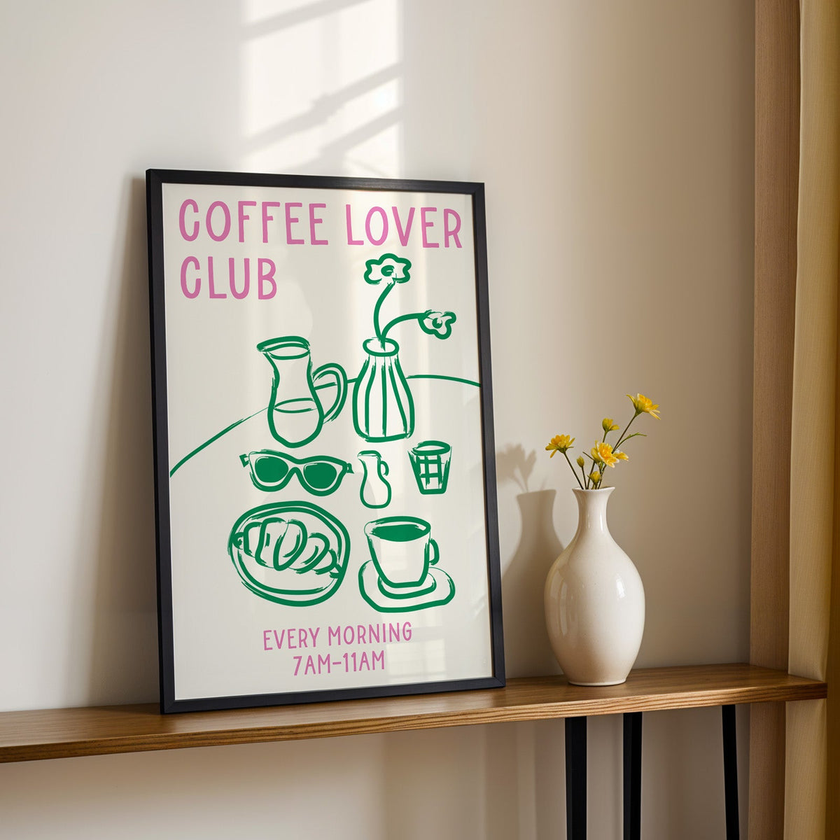 Coffee lover club morning print in a black frame on a console table with yellow daisies