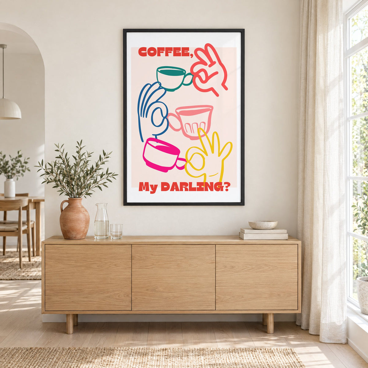 Coffee My Darling colorful hands print in a black frame above an oak sideboard with a terracotta vase of olive branches