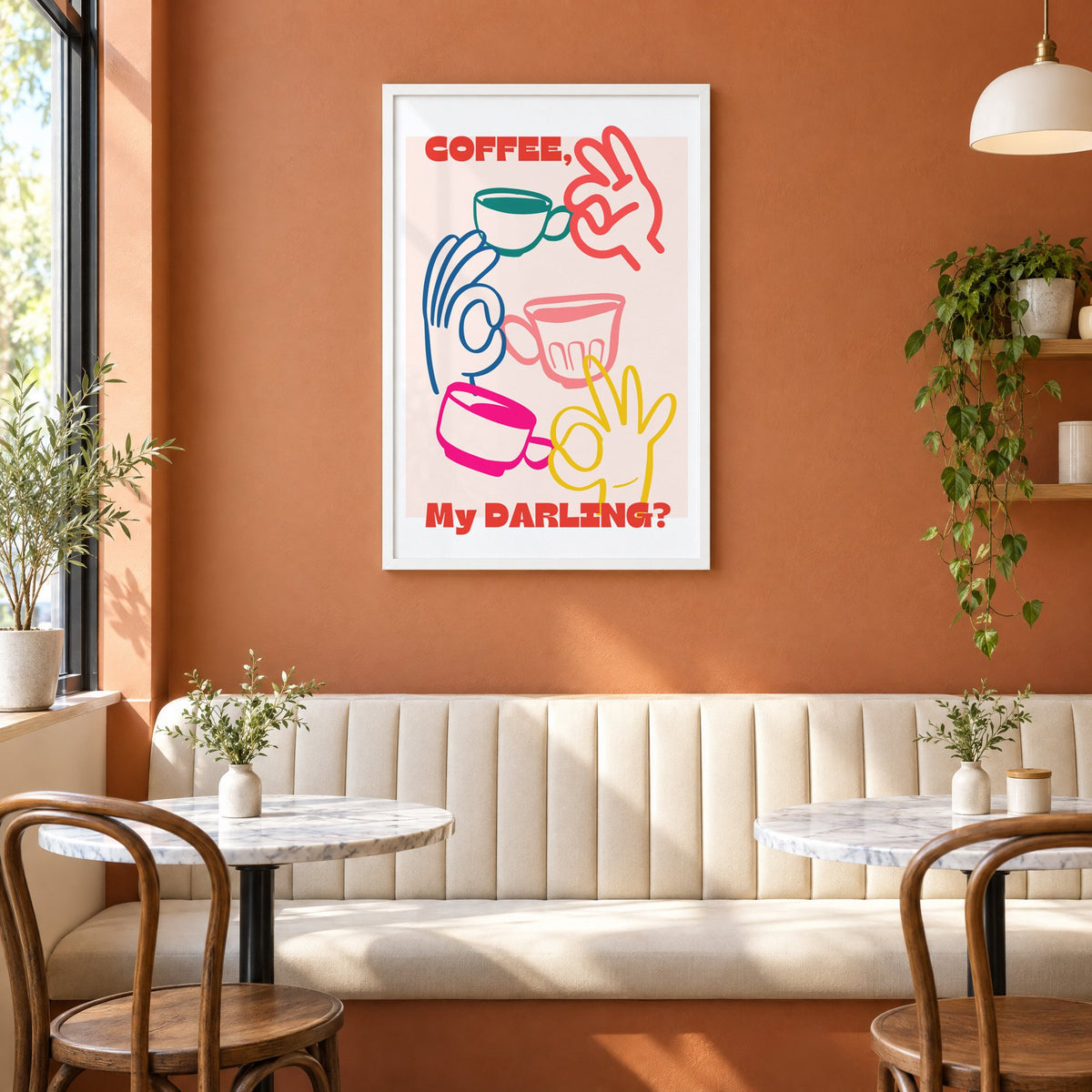 Coffee My Darling colorful hands print in a white frame above a cream banquette on a terracotta cafe wall