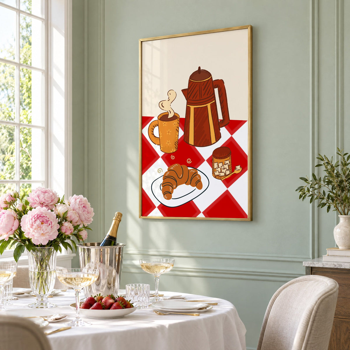 Coffee pot croissant red gingham print in a brass frame on a sage wall above a brunch table with champagne and peonies, seen at an angle