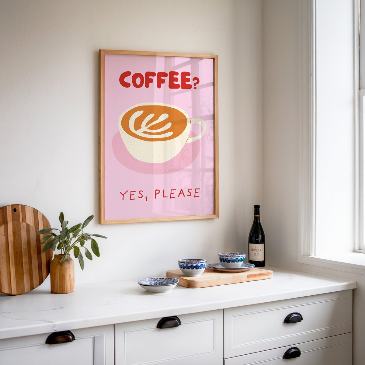Coffee Yes Please print in an oak frame above a white sideboard with a bottle of wine
