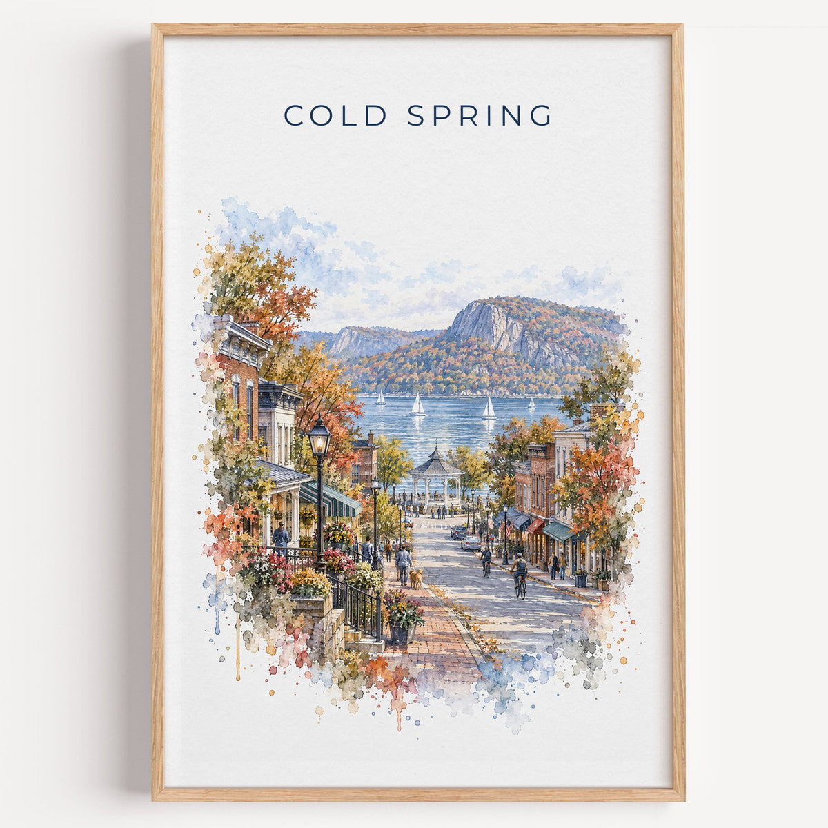 Cold Spring, New York watercolor print in a light oak frame on a plain white wall