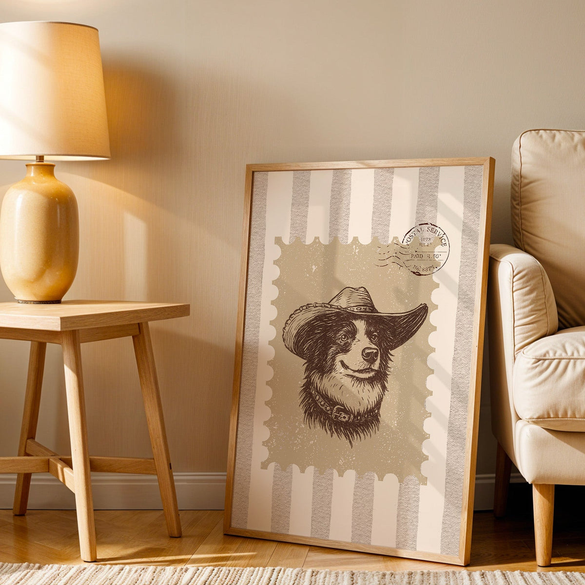 Collie cowboy hat stamp print in an oak frame beside an amber ceramic lamp
