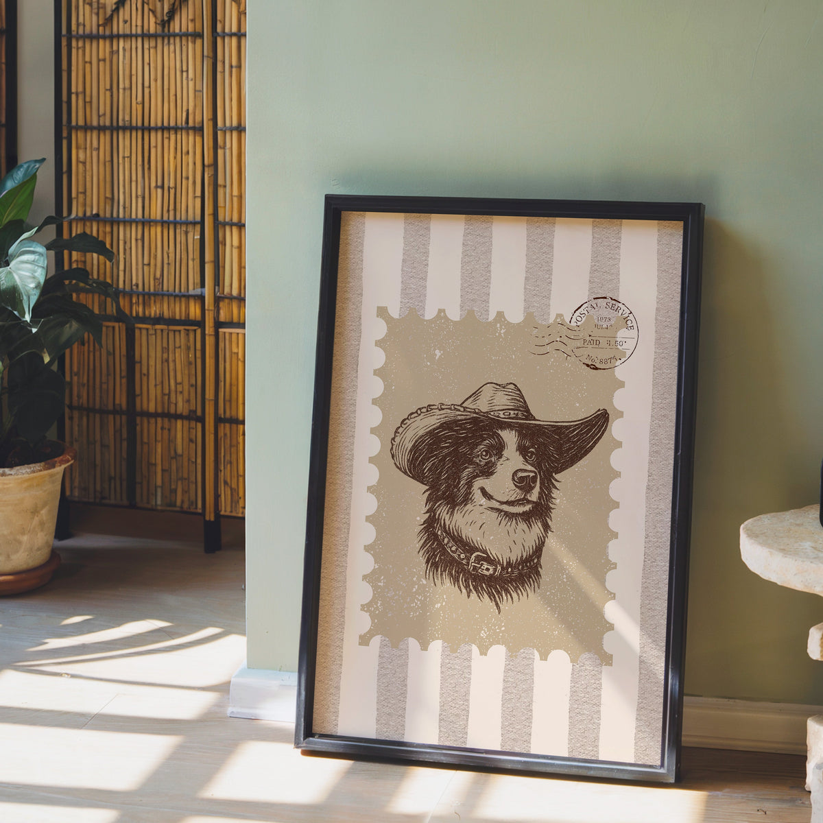 Collie cowboy hat stamp print in a black frame leaning against a sage green wall