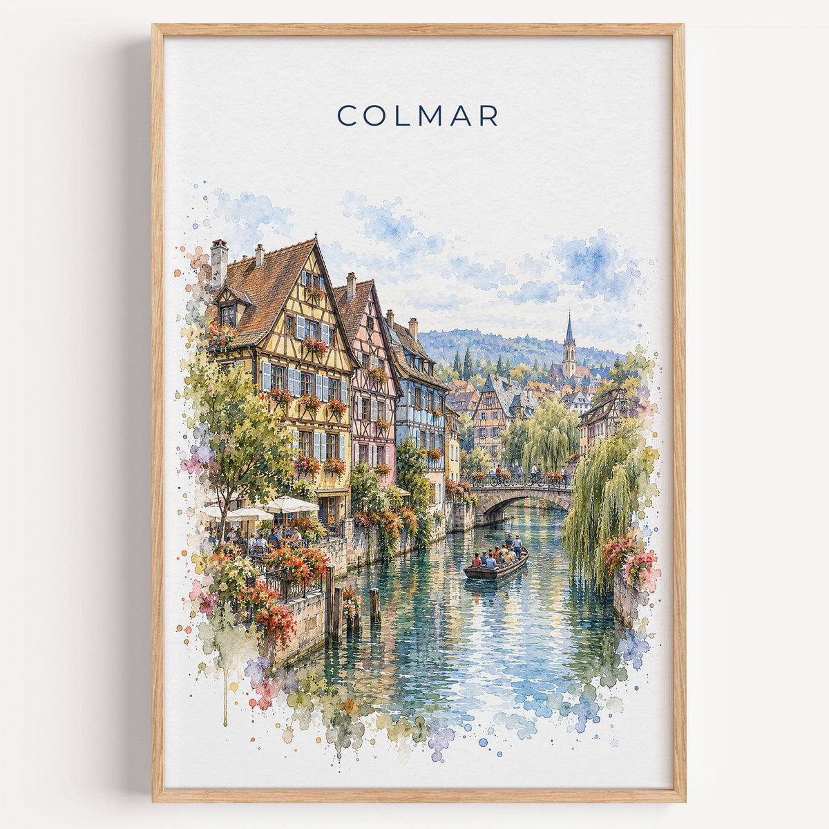 Colmar watercolor print in a light oak frame on a plain white wall