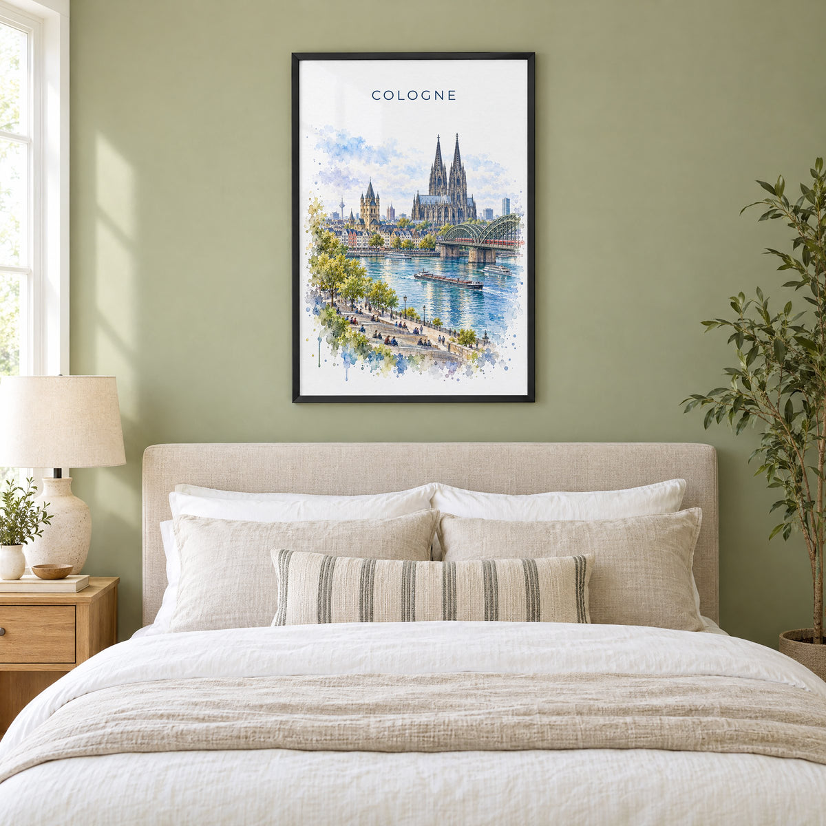 Cologne watercolor print in a black frame above an upholstered headboard in a sage green bedroom