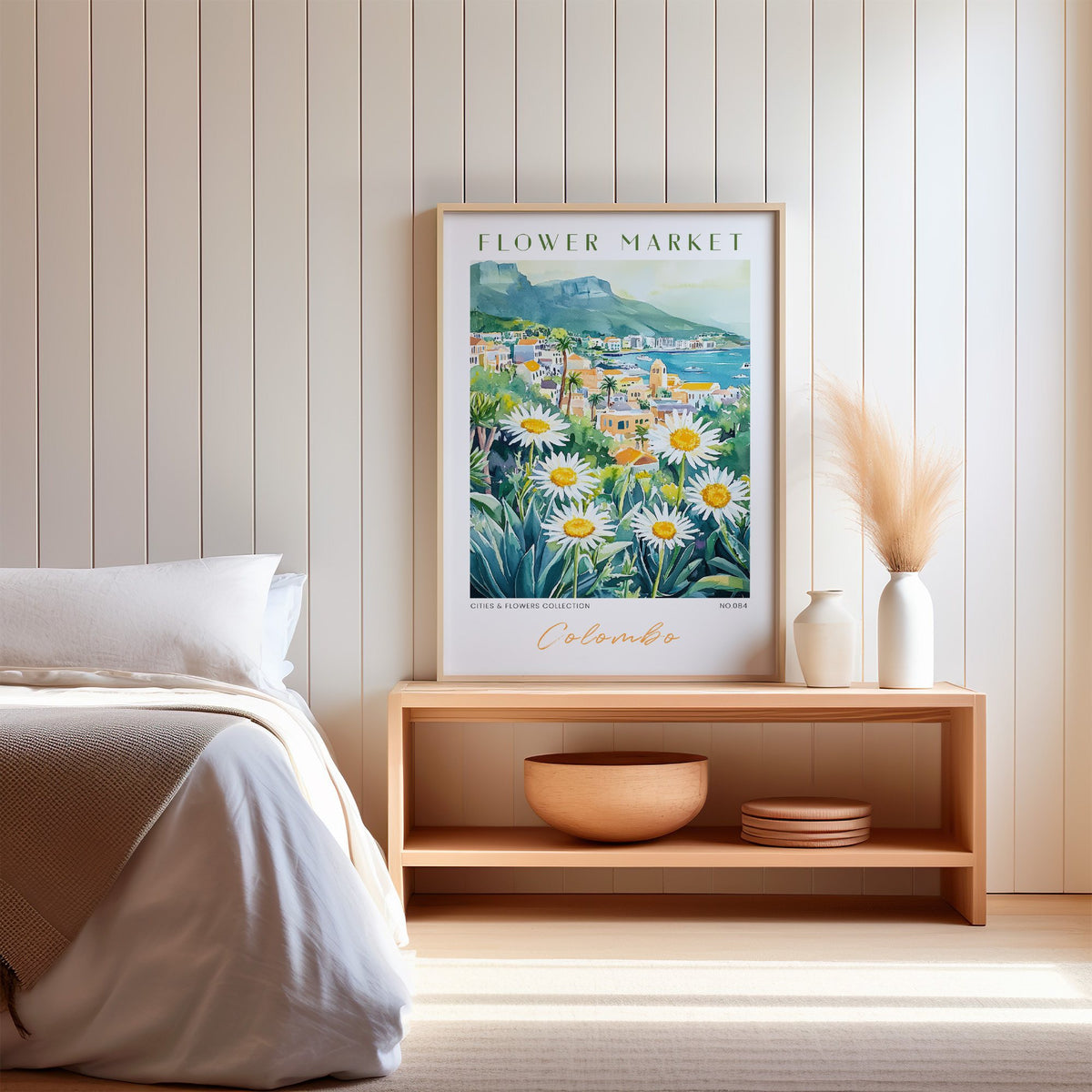Colombo flower market print in an oak frame on a wood bench against a white shiplap bedroom wall with pampas grass