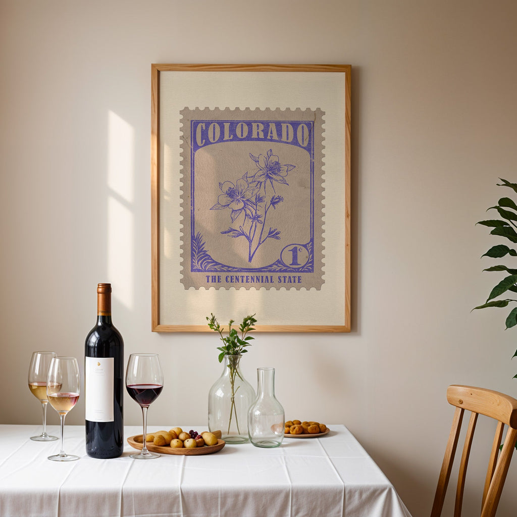 Colorado stamp print framed on the wall above a dining table set with wine, glasses and olives
