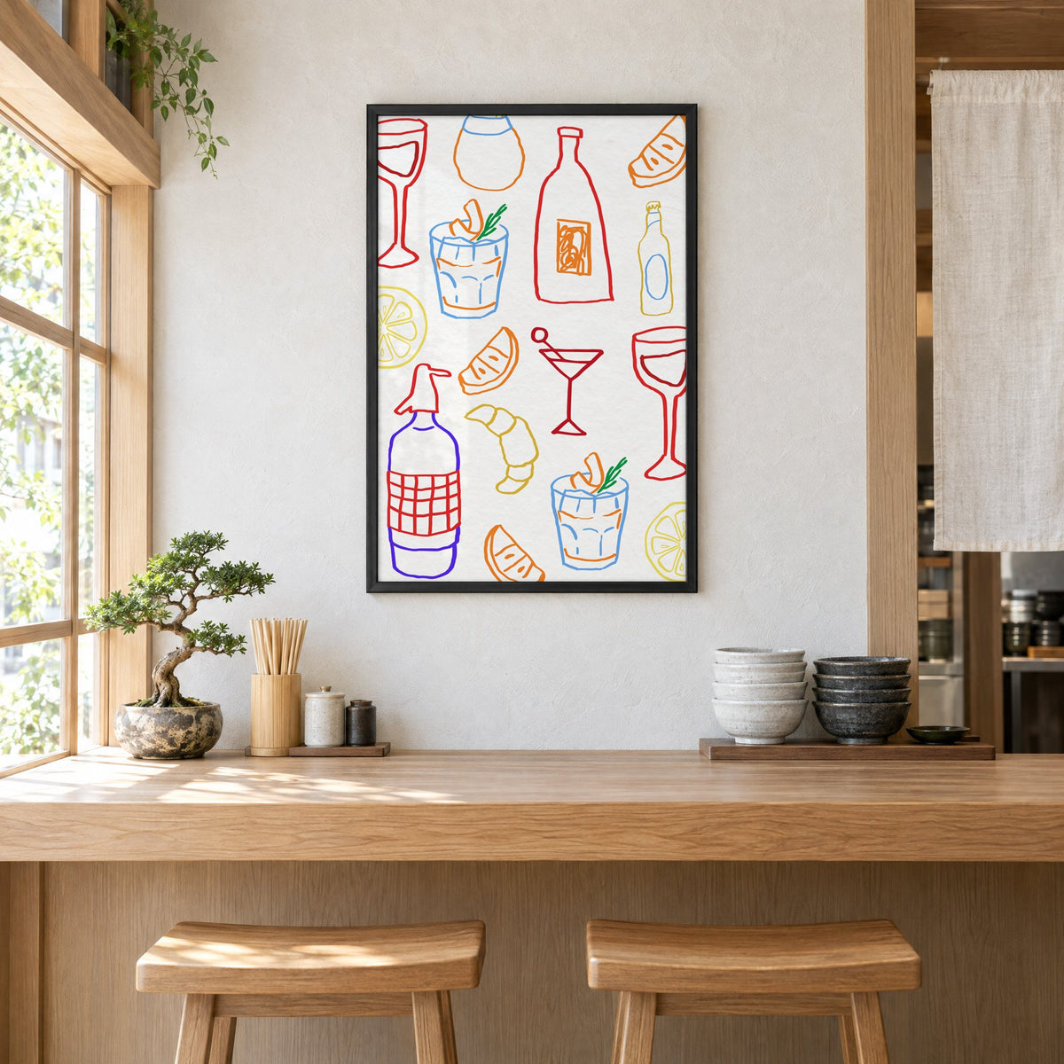 Colorful bar drinks doodle pattern print in a black frame above a light wood ramen counter with stools and stacked bowls