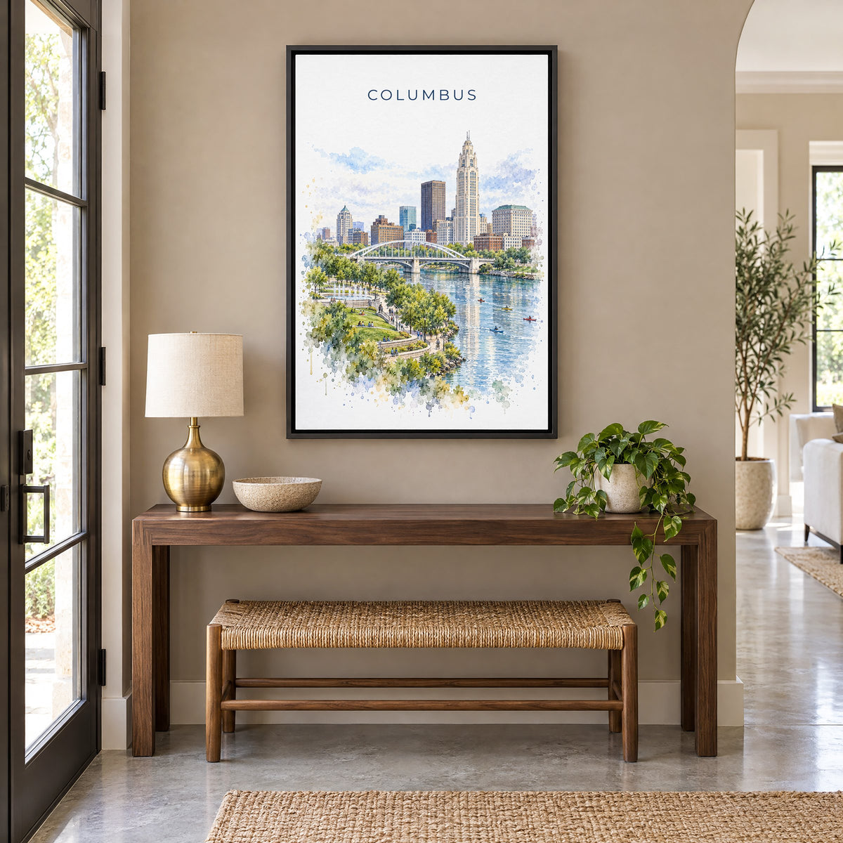 Columbus, Ohio watercolor print as a black floater canvas above a walnut console and woven bench in an entryway