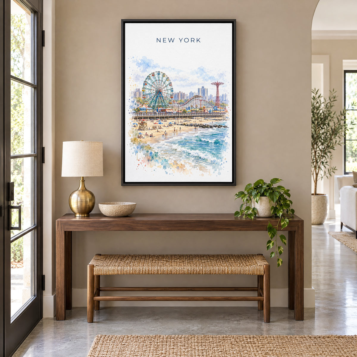 Coney Island watercolor print as a black floater canvas above a walnut console and woven bench in an entryway