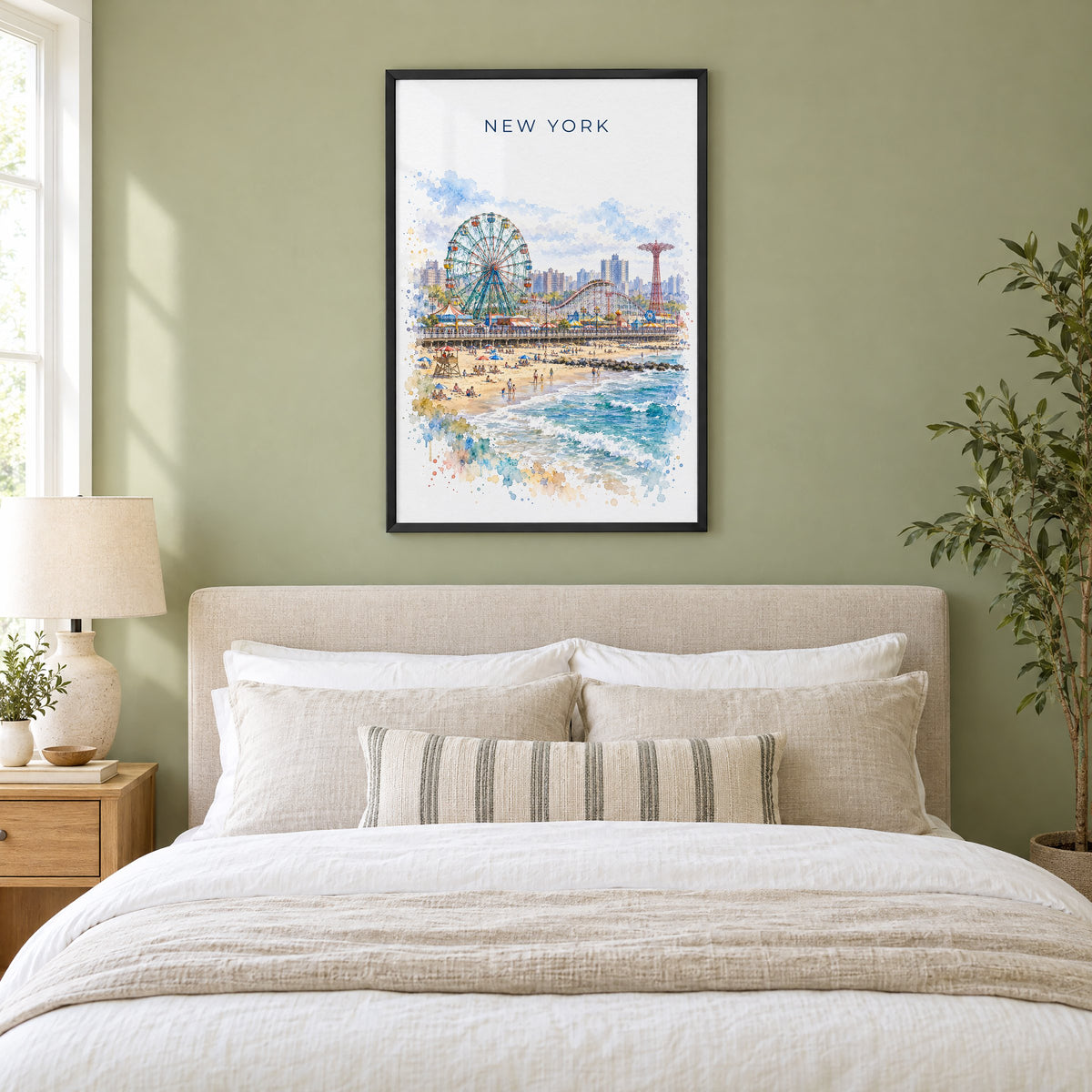 Coney Island watercolor print in a black frame above an upholstered headboard in a sage green bedroom