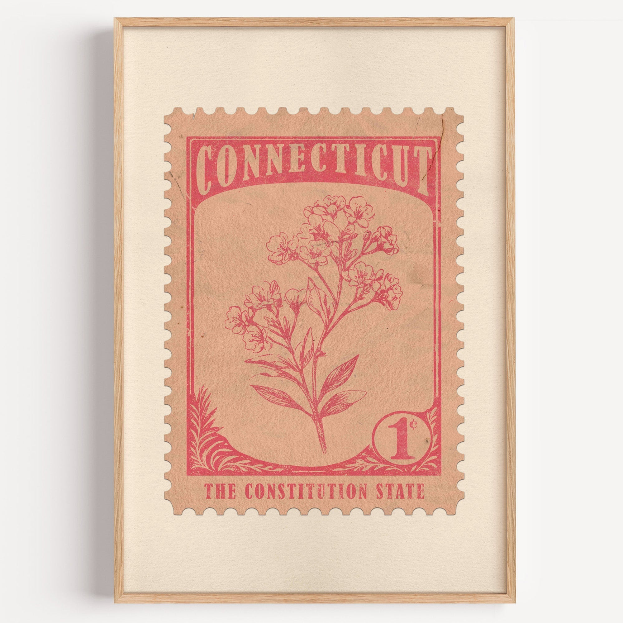 Connecticut state flower stamp print in coral red on blush, light oak frame on a plain white wall
