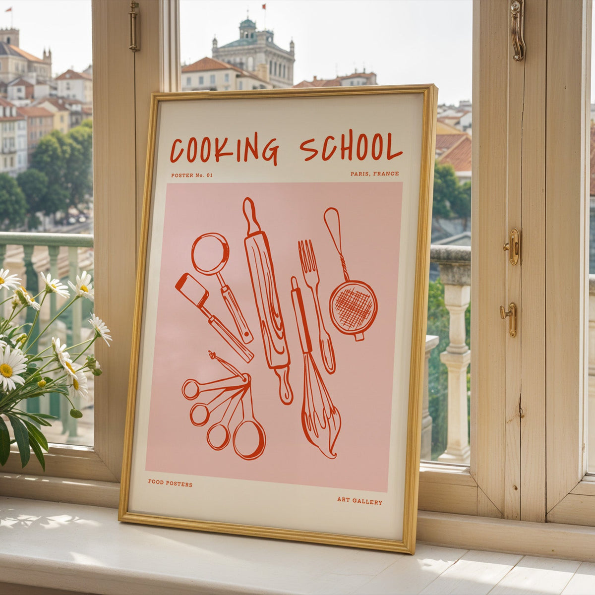Cooking School utensils print in a gold frame on a window sill above a hillside town
