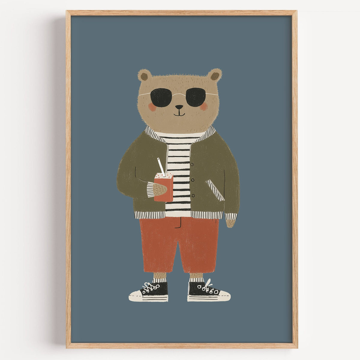 Cool bear sunglasses juice box nursery print in a light oak frame on a plain white wall