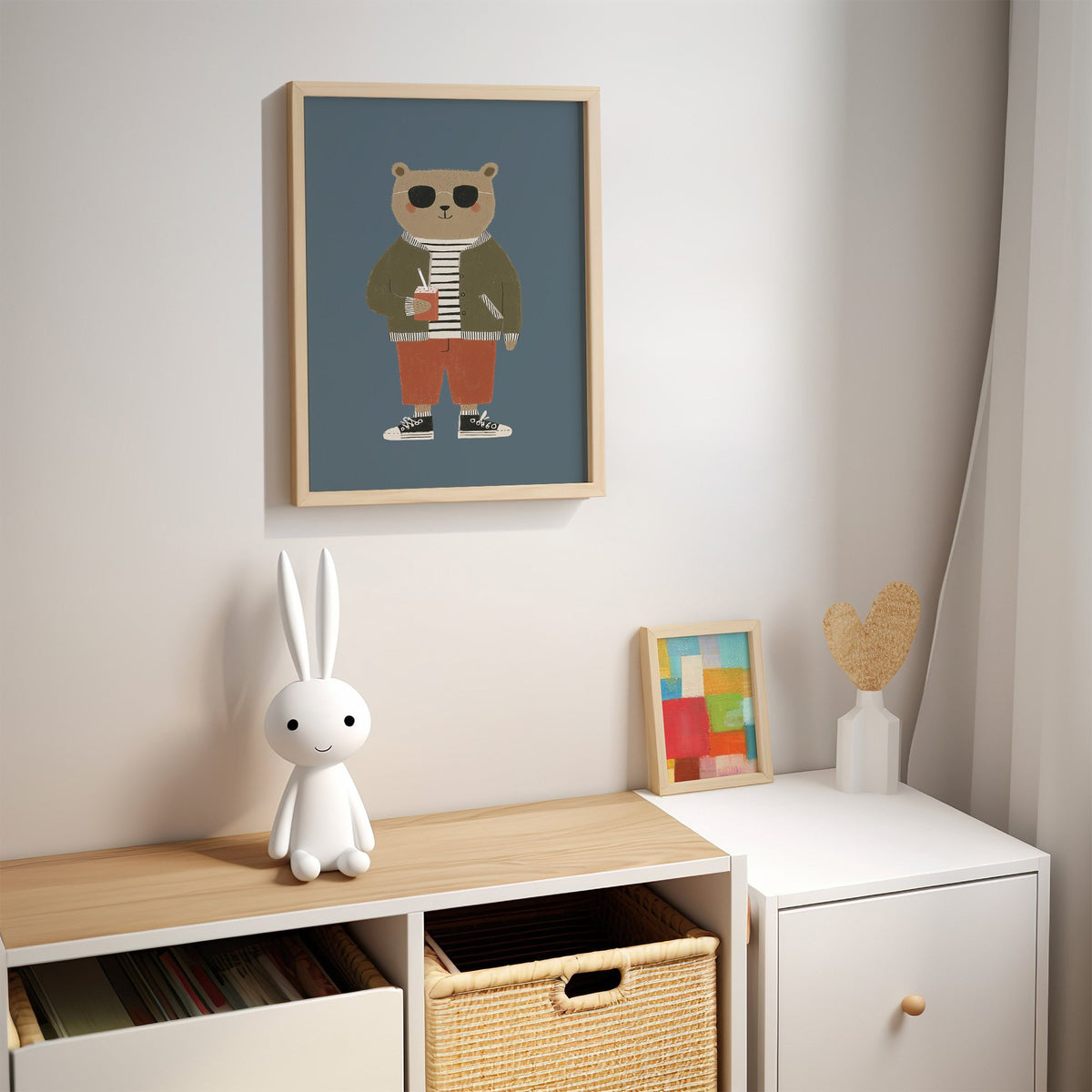 Cool bear sunglasses juice box nursery print in an oak frame above a kids cubby shelf with a woven basket and bunny lamp