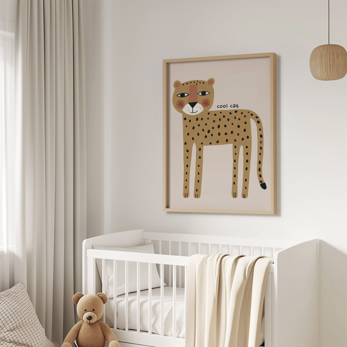 Cool cat cheetah nursery print in an oak frame above a white crib with a teddy bear