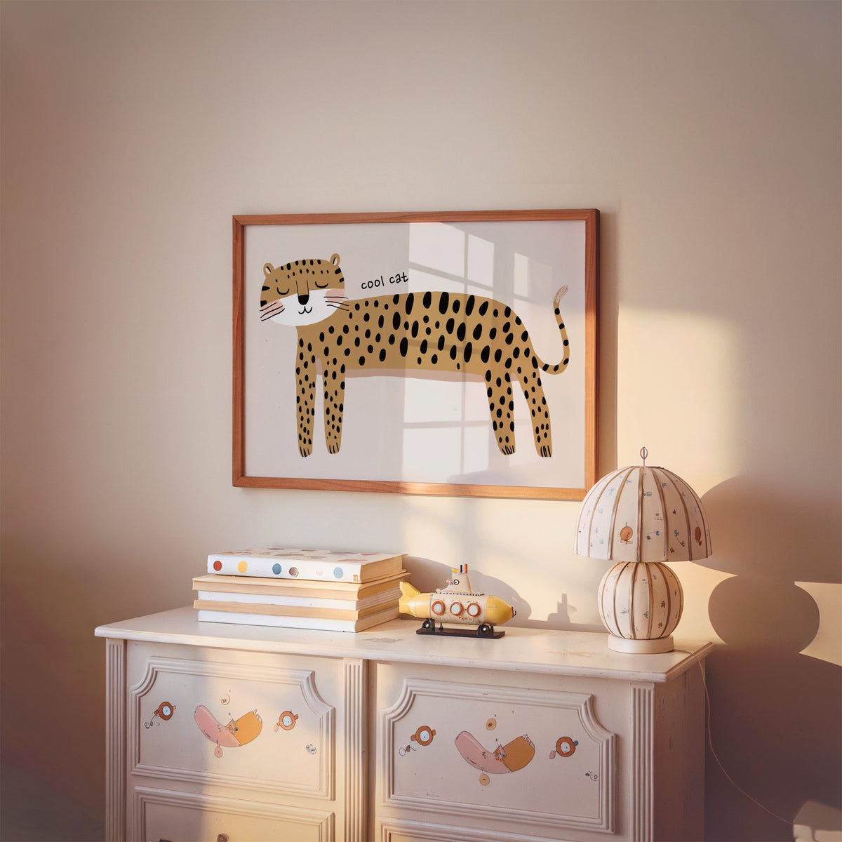 Landscape cool cat cheetah nursery print in a cherry wood frame above a painted dresser and lamp