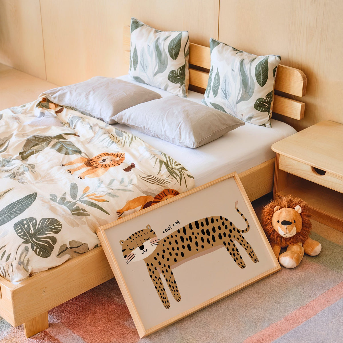 Landscape cool cat cheetah nursery print in an oak frame leaning on a kids bed by a lion plush