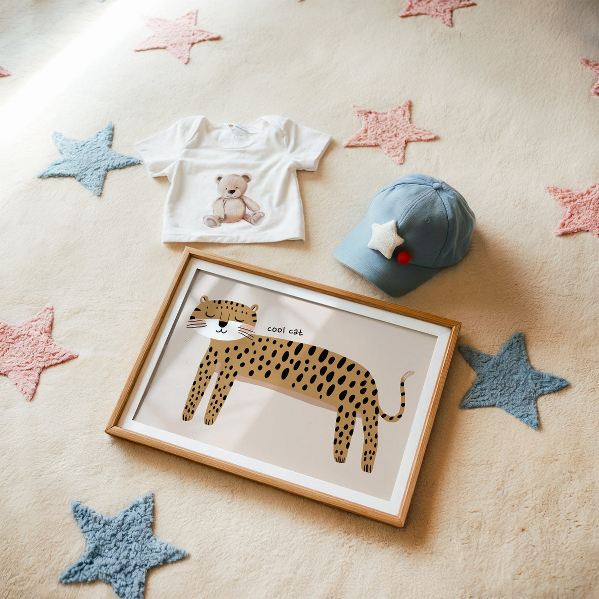 Landscape cool cat cheetah nursery print in a matted oak frame on a star rug with a baby tee