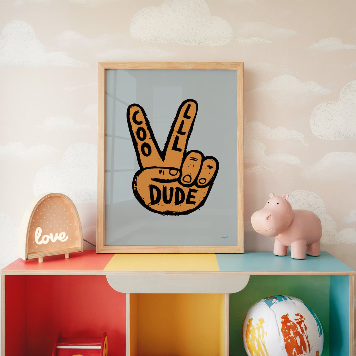 Cool dude peace sign hand nursery print in an oak frame on a rainbow toy shelf against cloud wallpaper