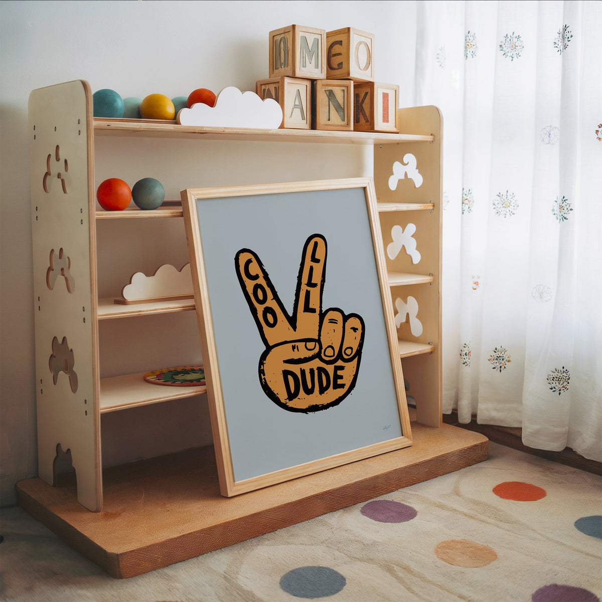 Cool dude peace sign hand nursery print in an oak frame leaning on a toy shelf with wooden letter blocks