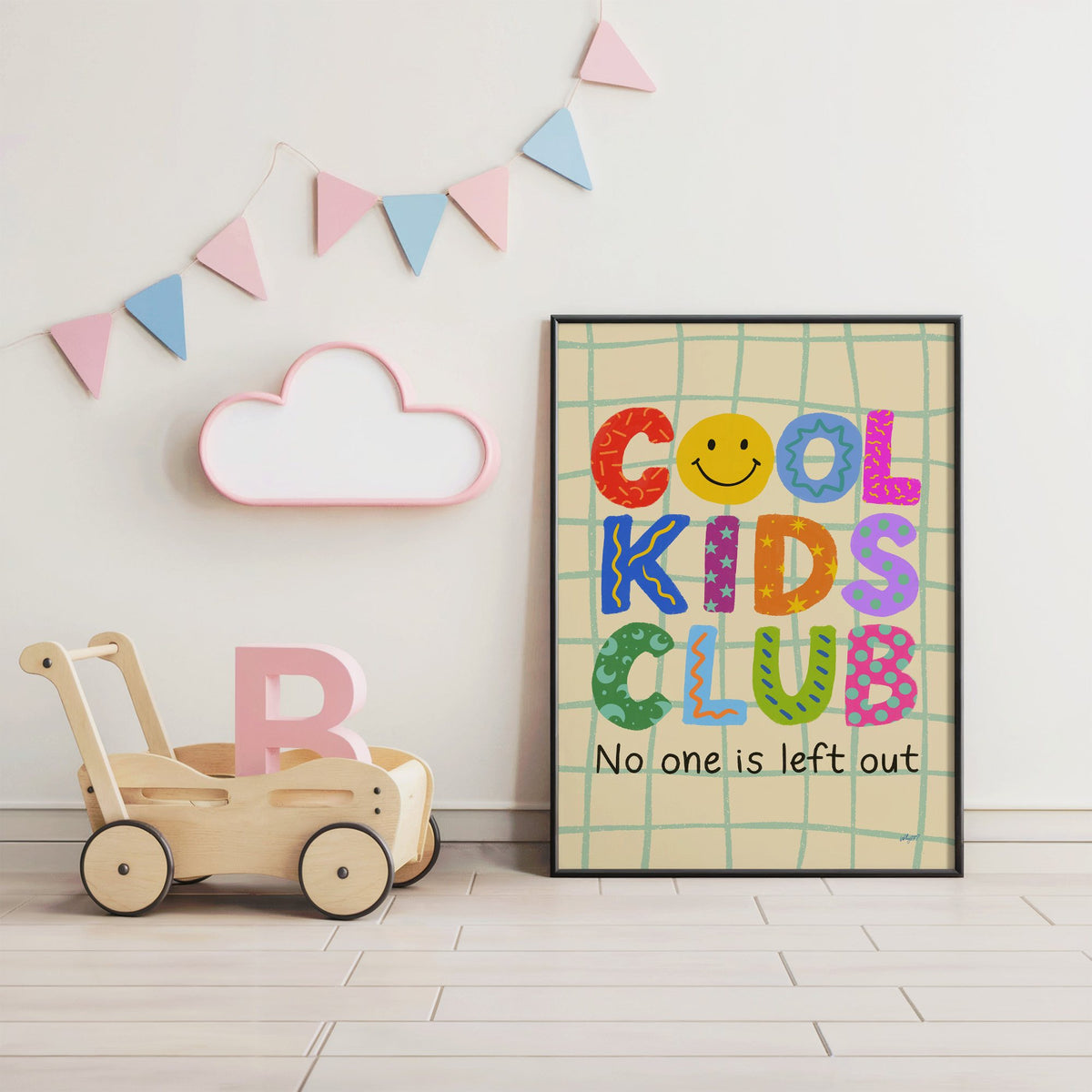 Cool kids club colourful letters nursery print in a black frame under pastel bunting by a wooden baby walker