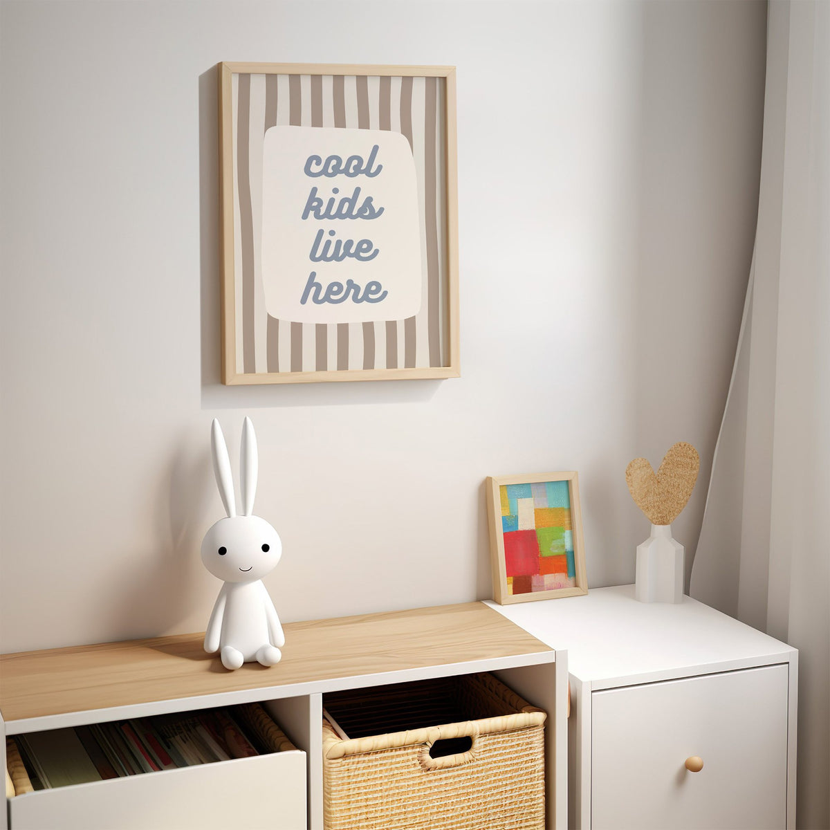 Cool kids live here nursery print in an oak frame above a kids cubby shelf with a woven basket and bunny lamp