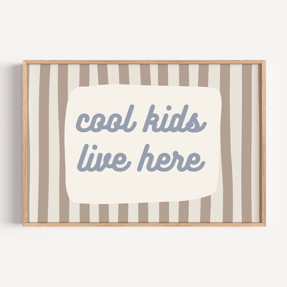 Landscape cool kids live here nursery print in a light oak frame on a plain white wall