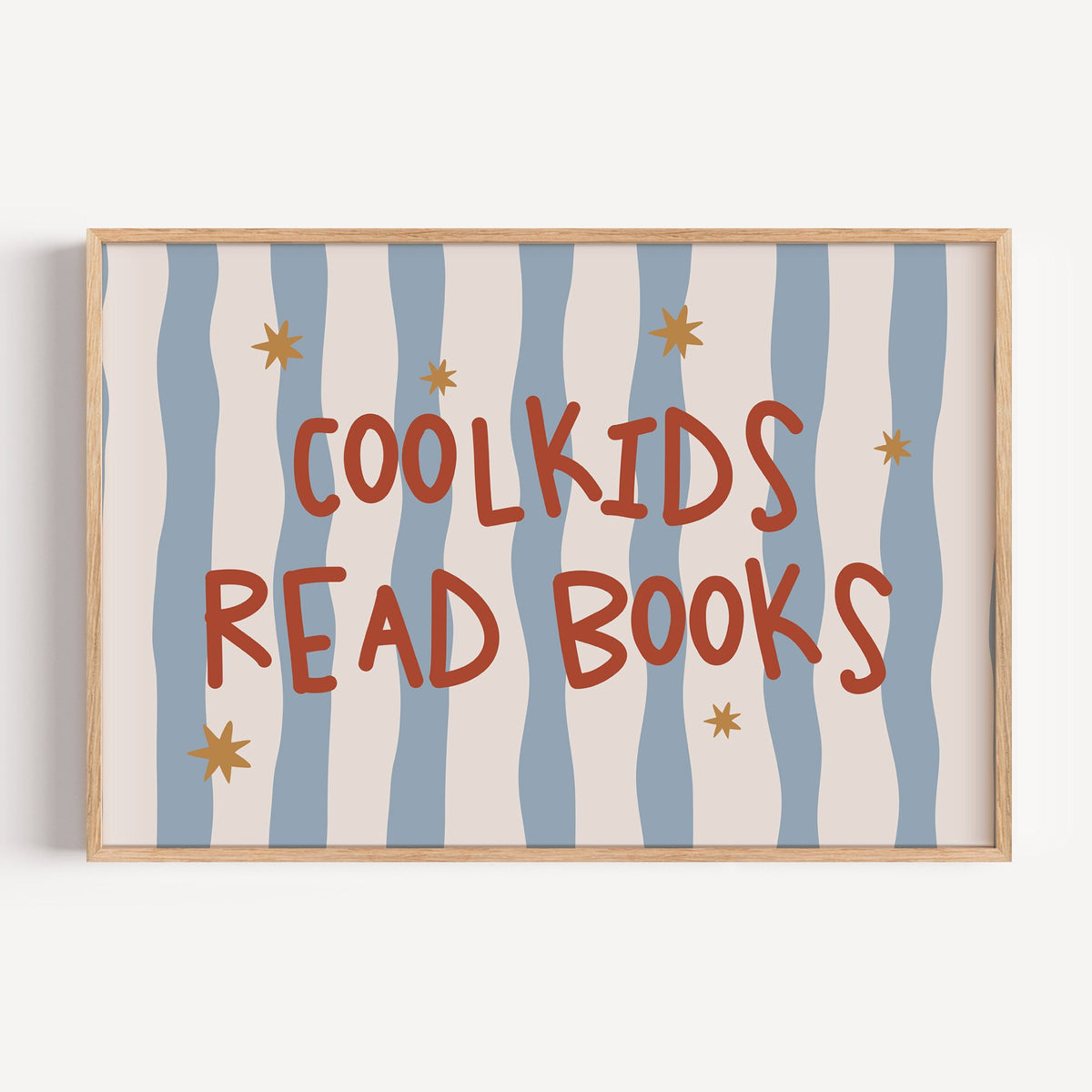 Landscape cool kids read books gold stars nursery print in a light oak frame on a plain white wall