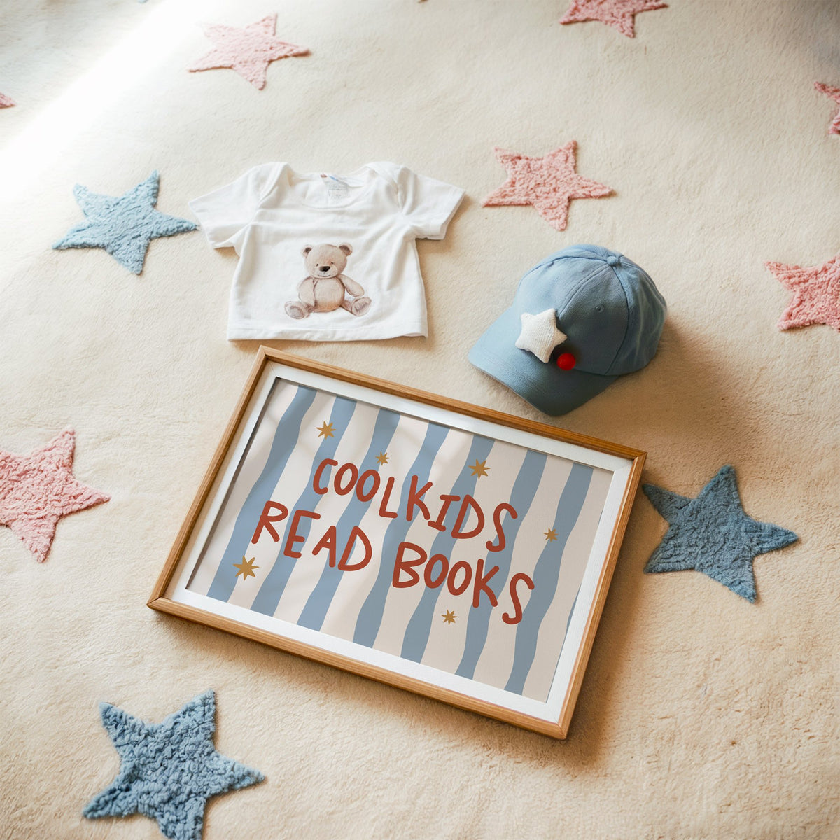 Landscape cool kids read books gold stars nursery print in a matted oak frame on a star rug with a baby tee