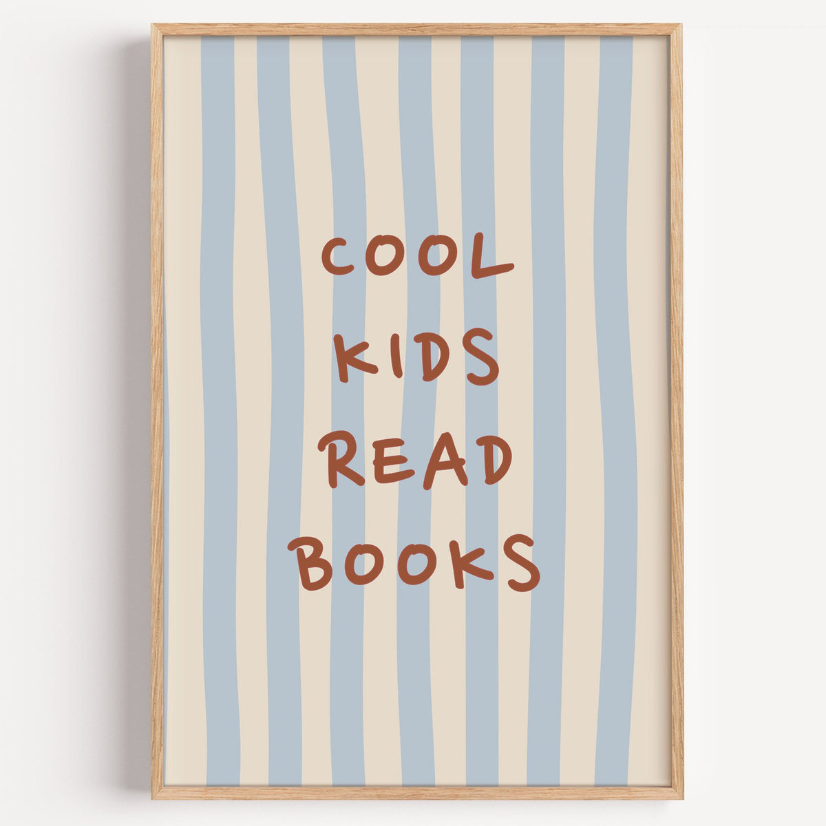 Cool kids read books blue stripe nursery print in a light oak frame on a plain white wall