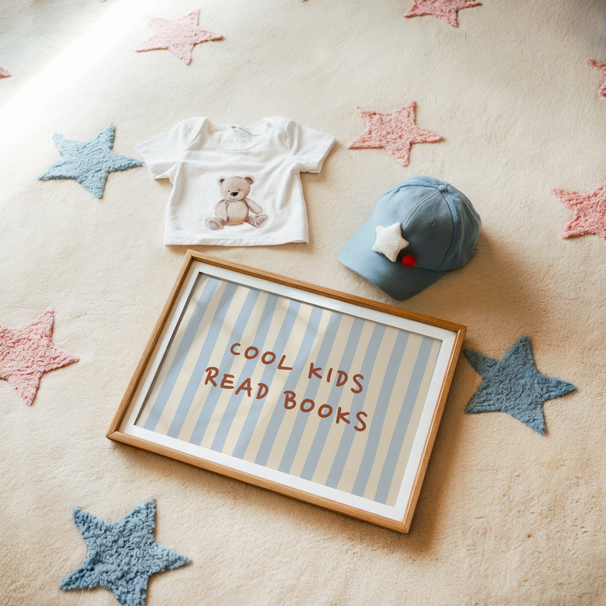 Landscape cool kids read books blue stripe nursery print in a matted oak frame on a star rug with a baby tee