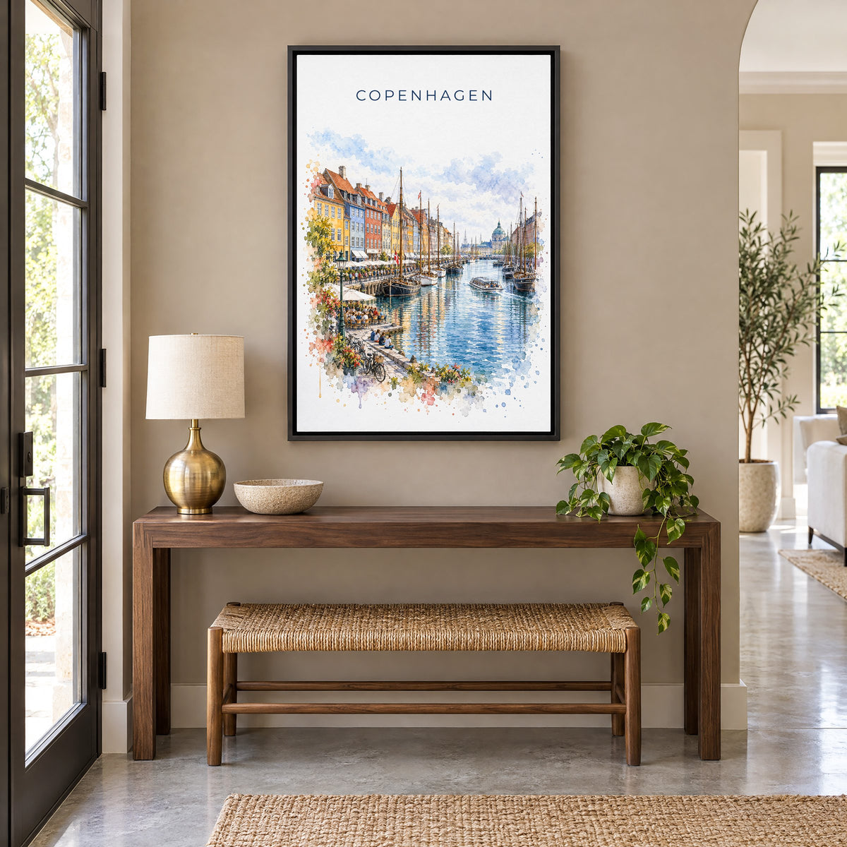 Copenhagen watercolor print as a black floater canvas above a walnut console and woven bench in an entryway