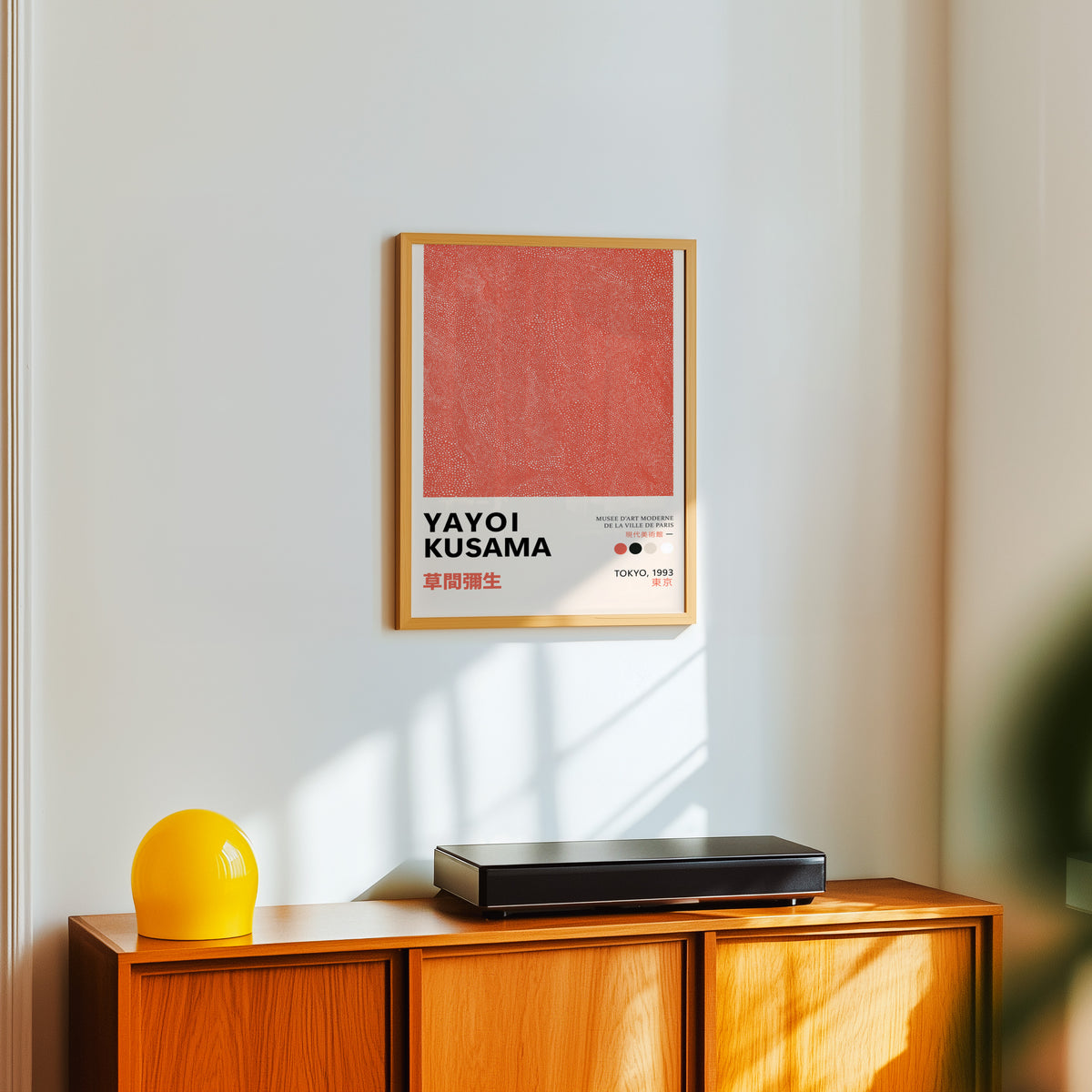 Yayoi Kusama inspired coral dotted texture print above a sideboard with a yellow lamp