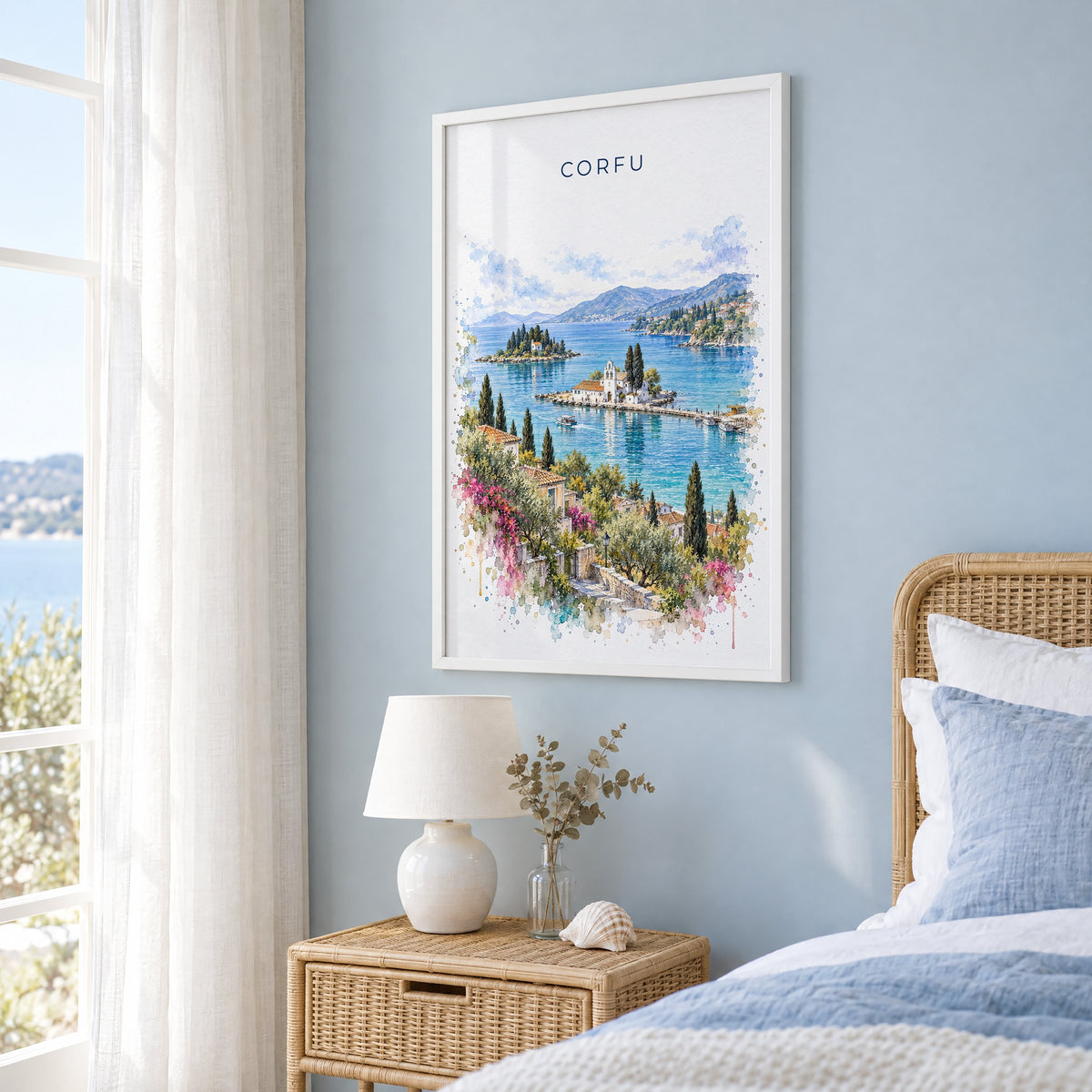 Corfu watercolor print in a white frame on a pale blue wall beside a rattan bed in a coastal bedroom