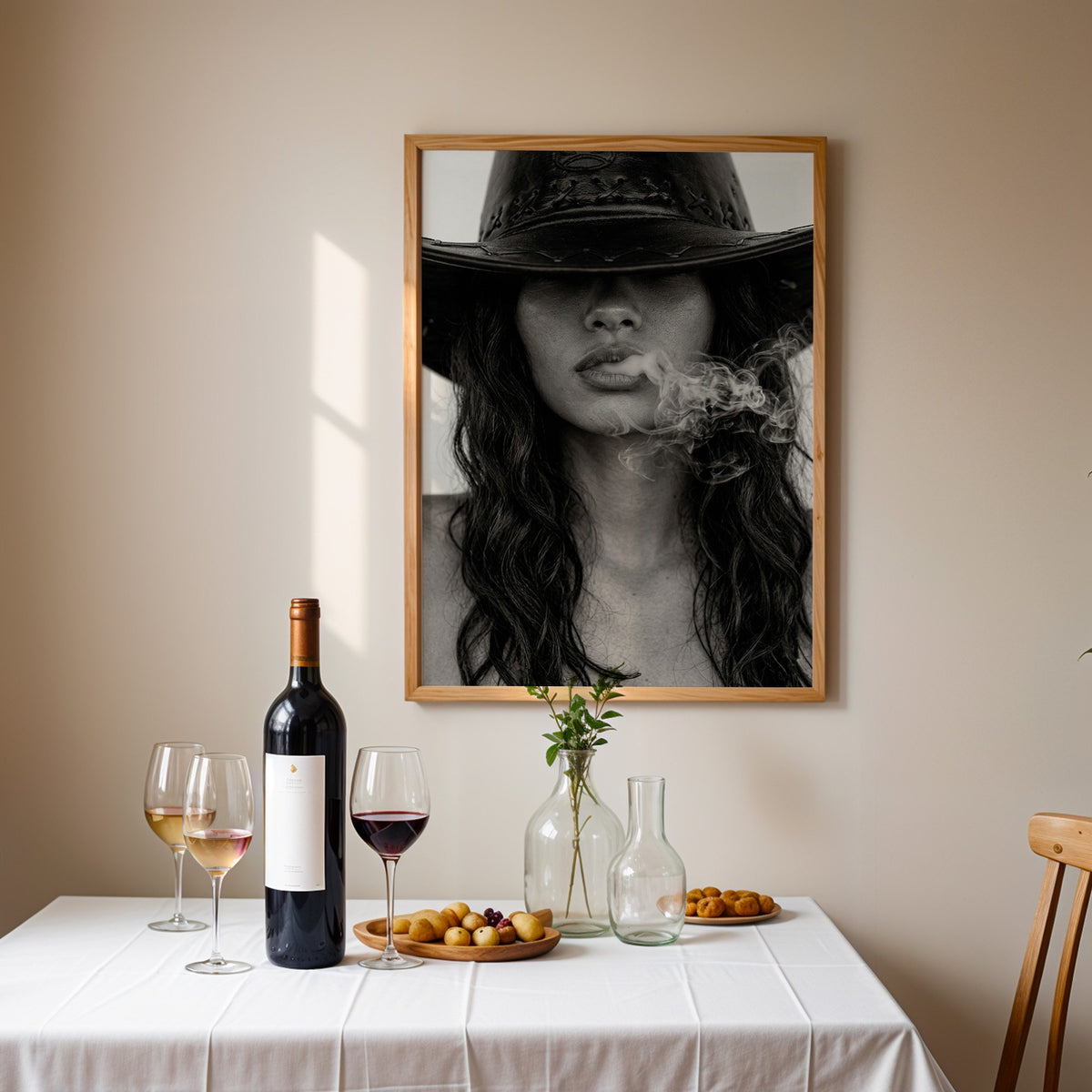 Cowboy hat brim and smoke from lips closeup print in an oak frame above a table set with red wine and glasses