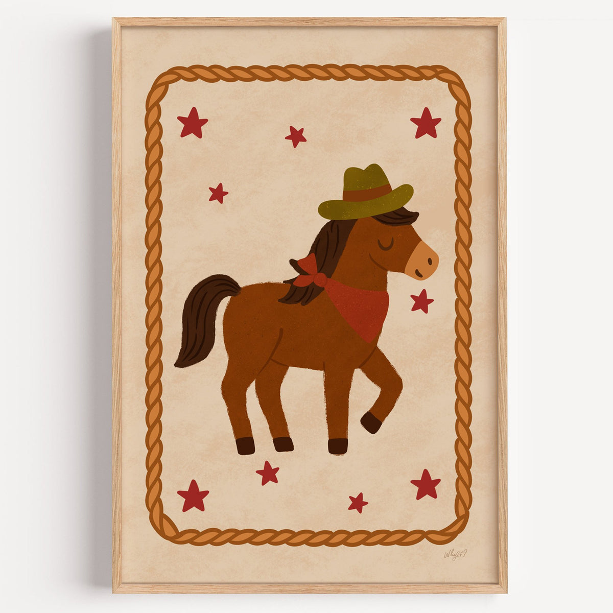 Cowboy pony in rope frame nursery print in a light oak frame on a plain white wall