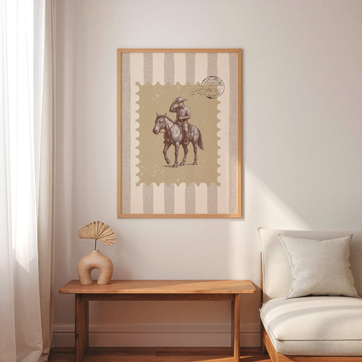 Cowboy tipping his hat stamp print in an oak frame above a console with an arch vase