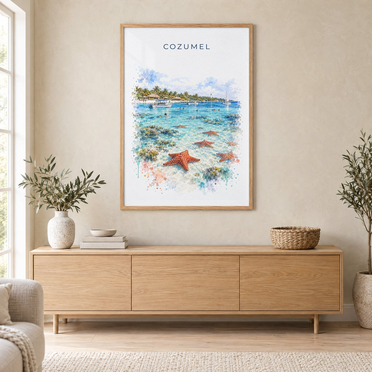 Cozumel watercolor print in an oak frame above a light wood sideboard in a Scandinavian living room