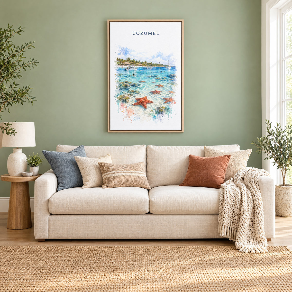Cozumel watercolor print as a natural floater canvas above a cream linen sofa on a sage green wall