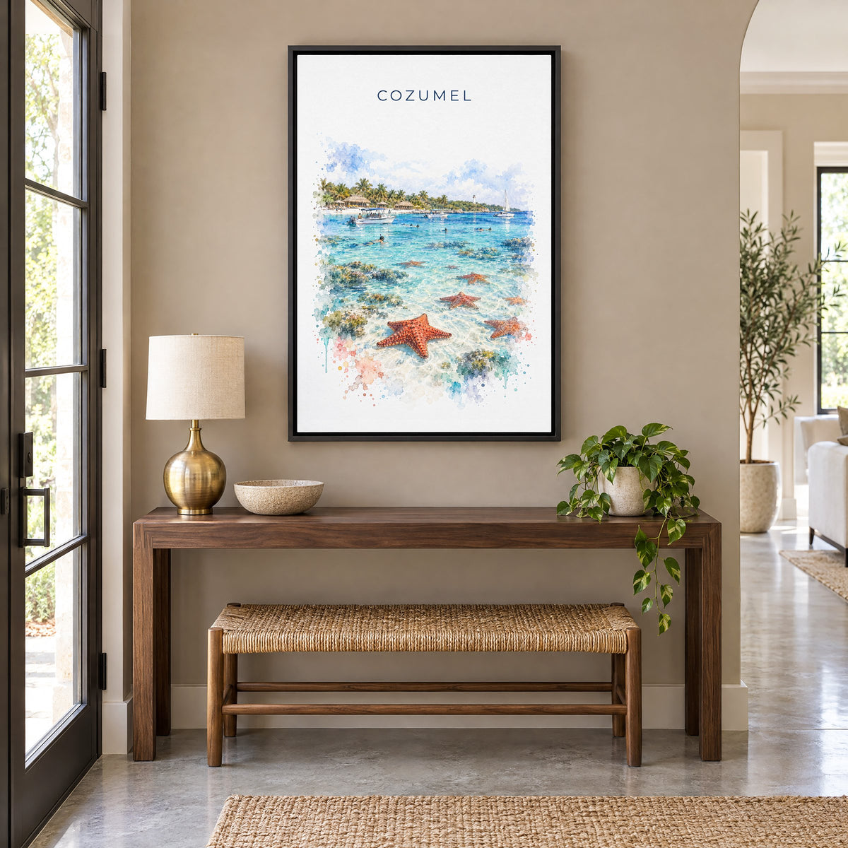 Cozumel watercolor print as a black floater canvas above a walnut console and woven bench in an entryway