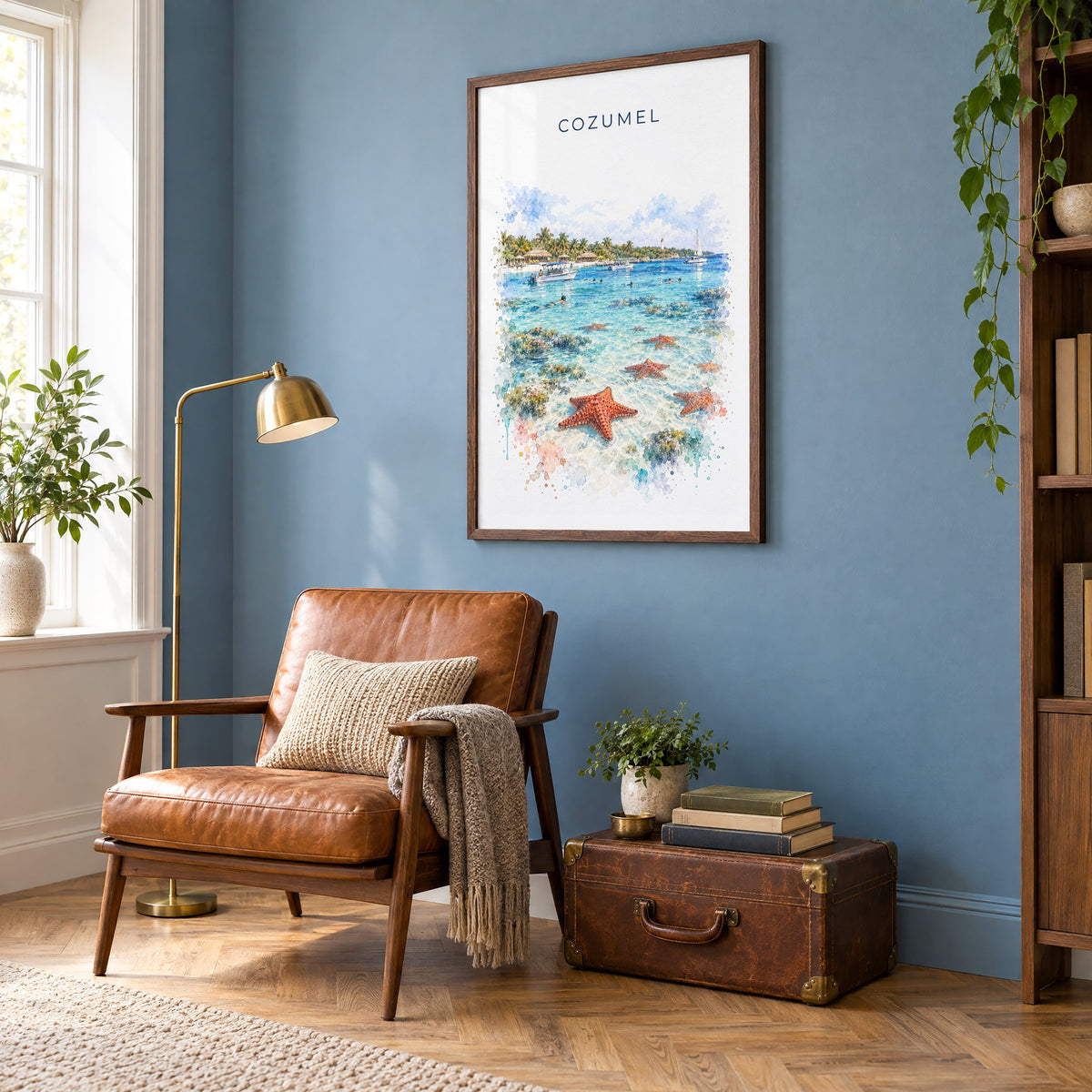 Cozumel watercolor print in a walnut frame on a blue wall above a leather armchair in a reading nook