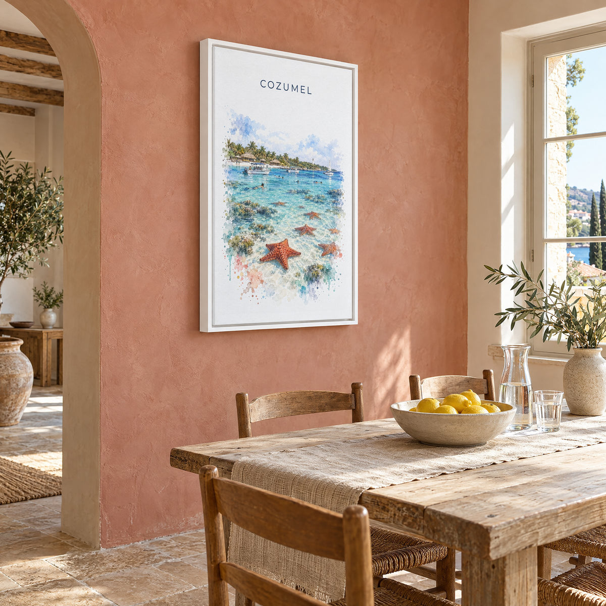 Cozumel watercolor print as a white floater canvas on a terracotta wall above a rustic dining table