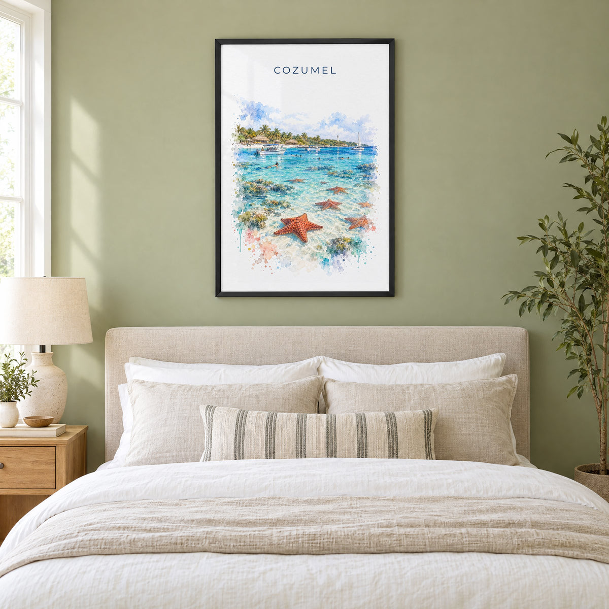 Cozumel watercolor print in a black frame above an upholstered headboard in a sage green bedroom