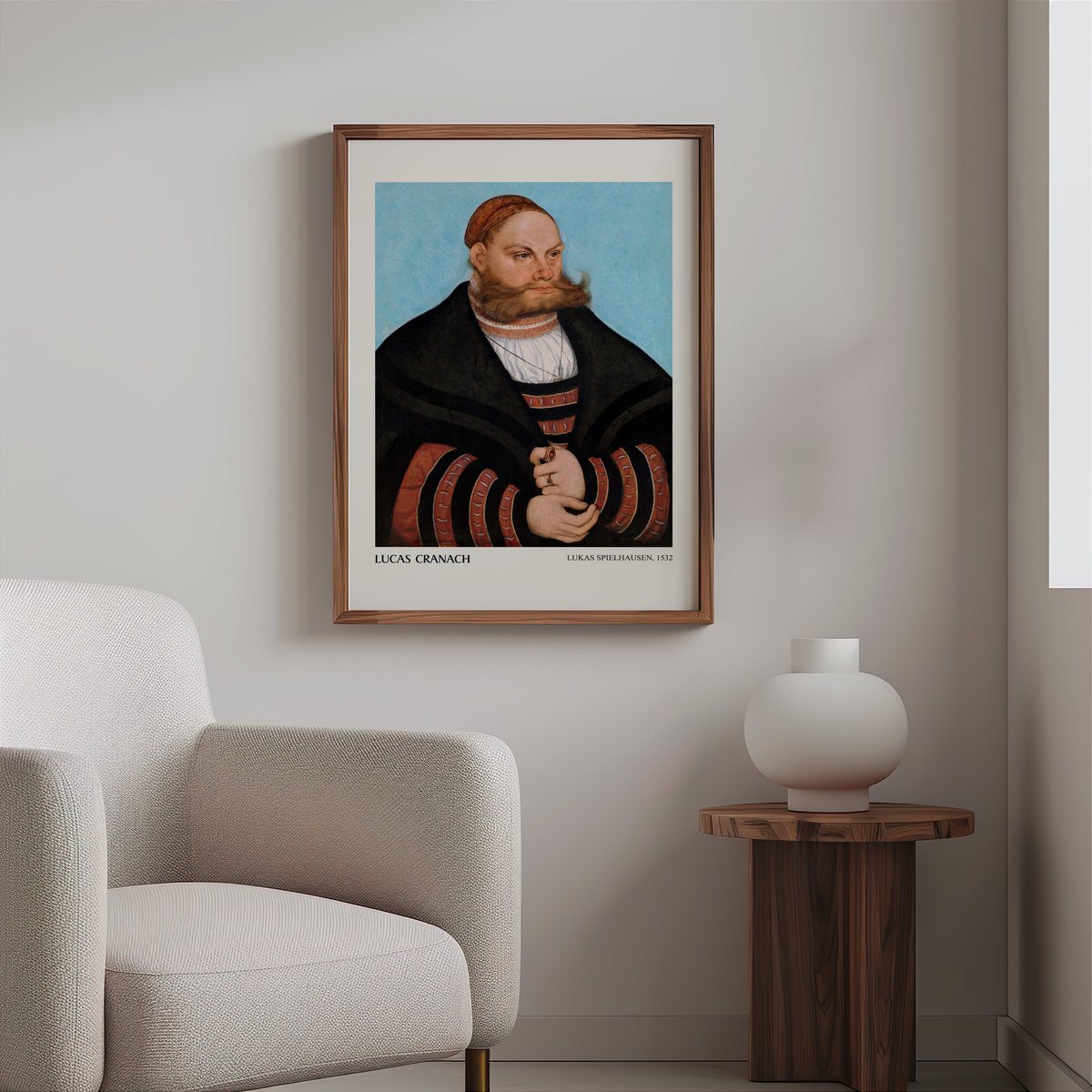 Renaissance portrait print in a slim walnut frame above a bouclé armchair